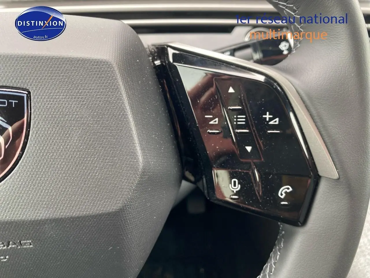 Gros plan sur les commandes multifonctions noires du côté droit du volant cuir d'une Peugeot 3008 bleu 2025.