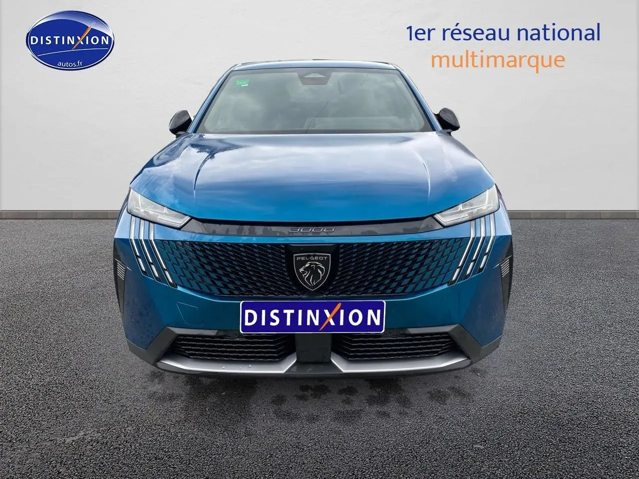 Vue frontale d'un Peugeot 3008 bleu 2025 avec calandre noire et phares LED fins allumés.