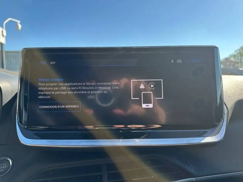 Écran tactile central du Peugeot 2008 2025 en gros plan, affichant l'option Mirror Screen dans un intérieur lumineux.