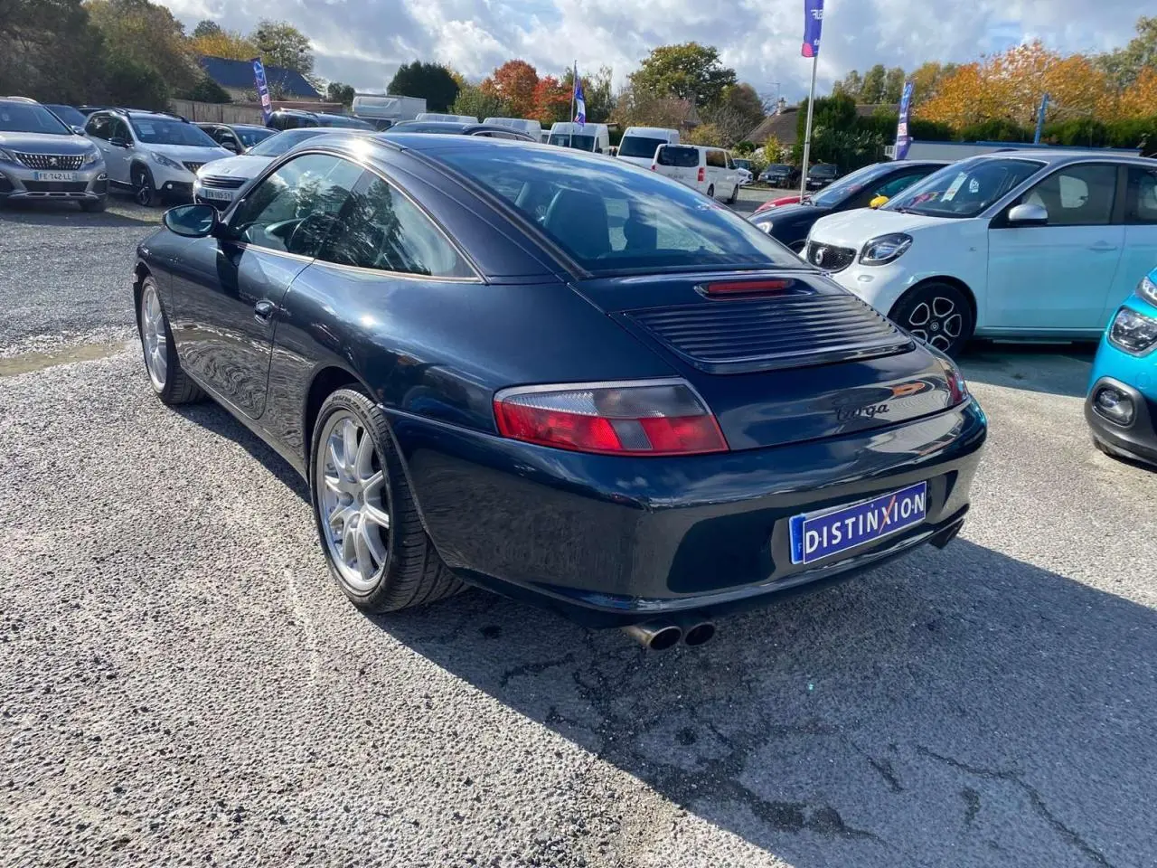 Vue 3/4 arrière droite d'une Porsche 911 Targa 996 gris foncé avec aileron et double sortie d'échappement sport.
