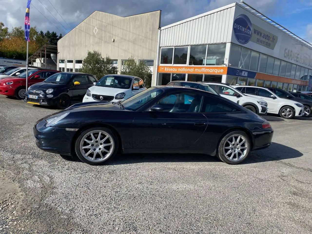 Profil côté gauche d'une Porsche 911 Targa 996 gris foncé avec jantes Sport Design 18 pouces, stationnée en extérieur.
