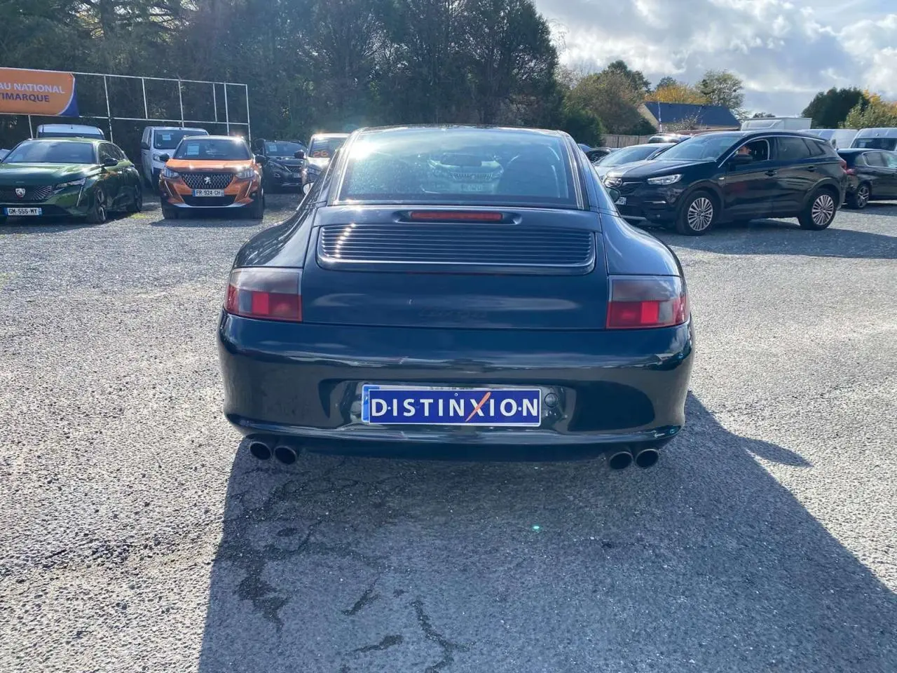 Vue arrière d'une Porsche 911 Targa 996 gris foncé avec double sortie d'échappement sport et aileron arrière visible.