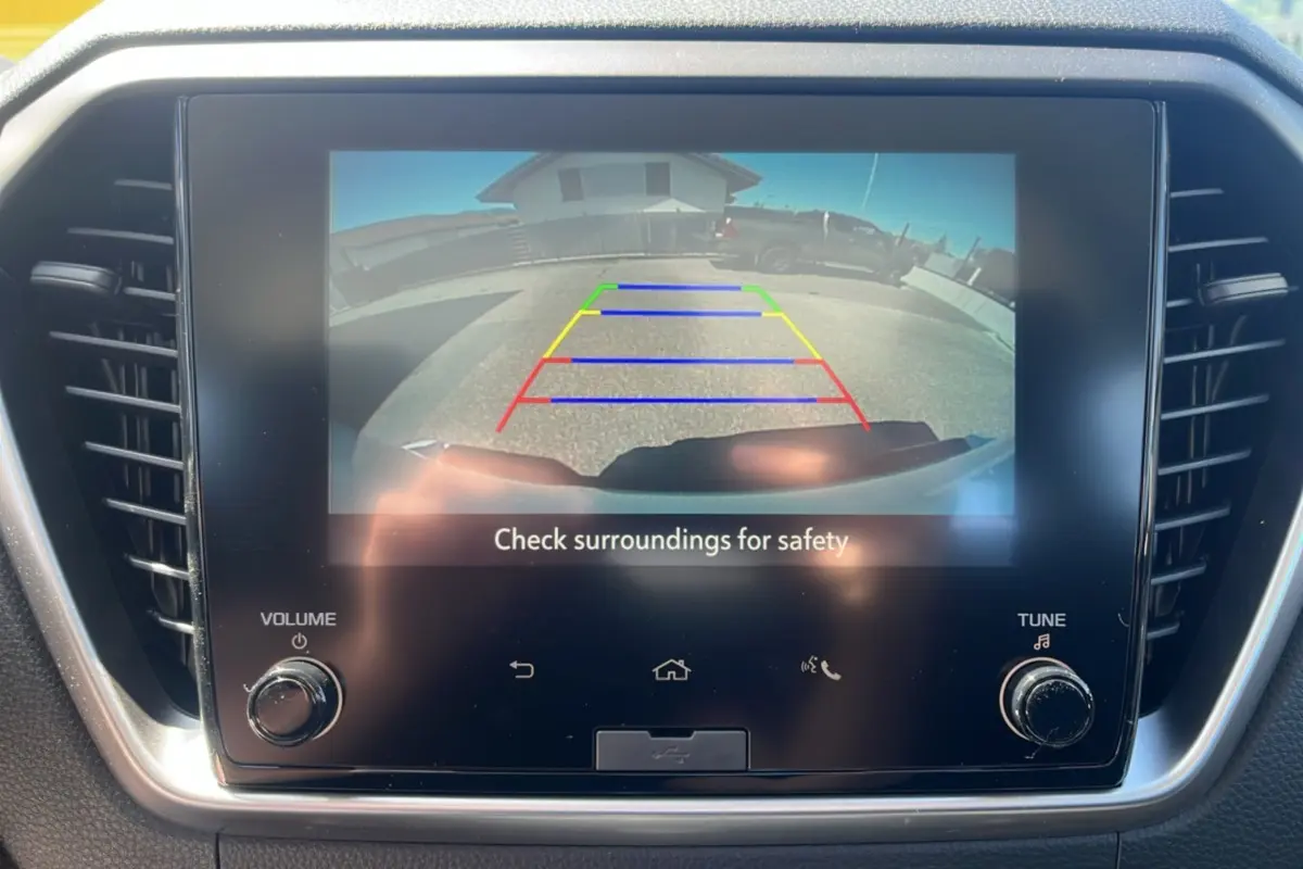Écran tactile intérieur affichant la caméra de recul du pick-up Isuzu D-MAX blanc, vue arrière avec repères colorés.