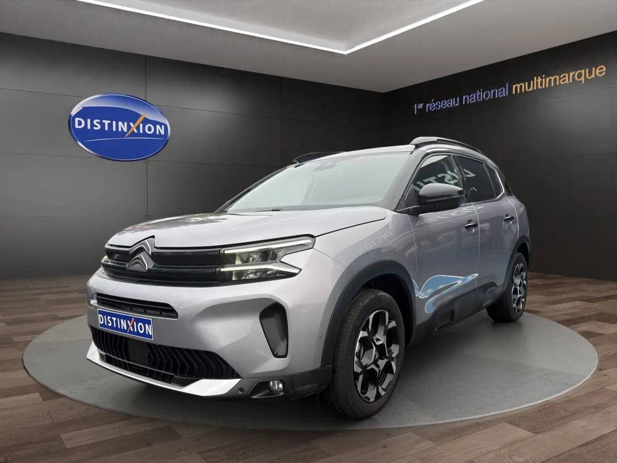 Citroën C5 Aircross hybride gris clair vue 3/4 avant droit, avec jantes distinctives et toit noir.