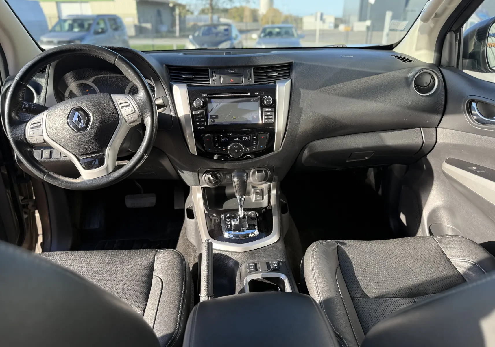 Intérieur du Renault Alaskan 2018, vue frontale du tableau de bord avec volant cuir et écran tactile central.