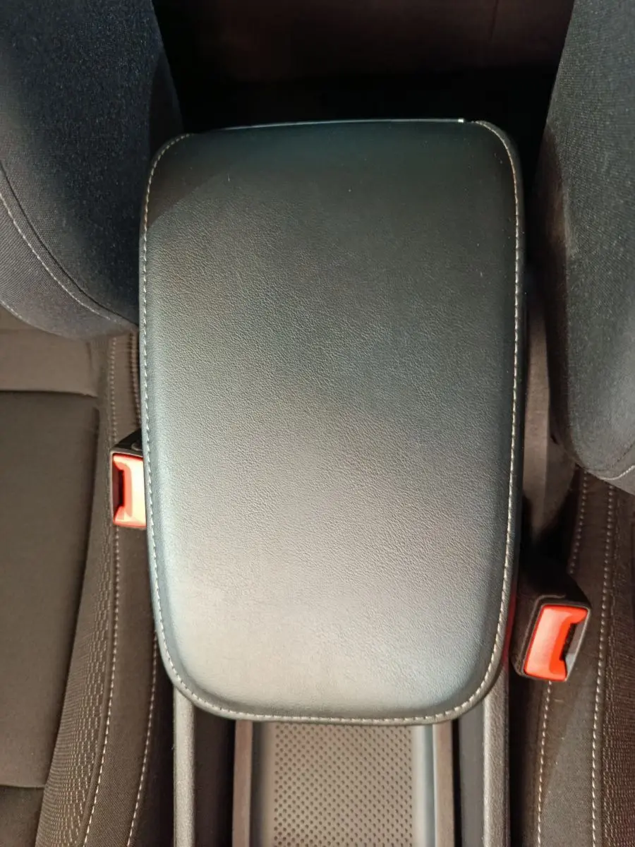 Accoudoir central en cuir noir avec surpiqûres blanches dans l'habitacle du Skoda Karoq blanc 2024.