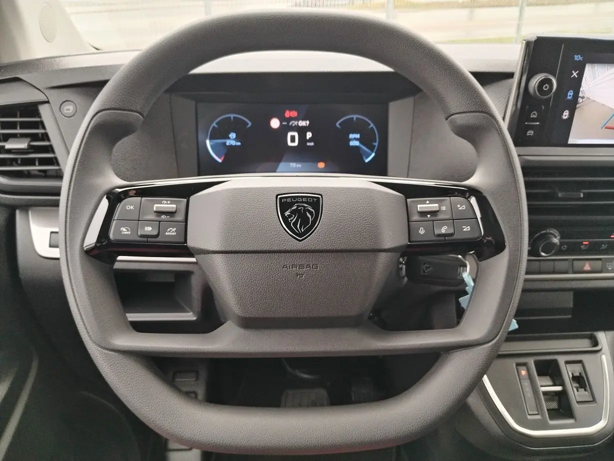 Vue rapprochée du volant multifonction noir du Peugeot Expert Cabine Approfondie 2025 avec tableau de bord digital et écran tactile.