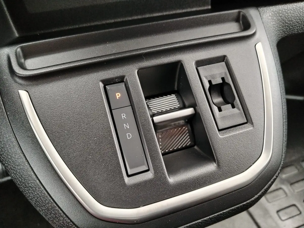 Gros plan sur la console centrale noire du Peugeot Expert M 2.0 BlueHDi 180, avec commandes de boîte auto et finition argentée.