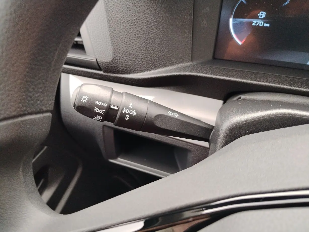 Gros plan sur la commande des feux et clignotants à gauche du volant dans le tableau de bord gris du Peugeot Expert Cabine Approfondie 2025.