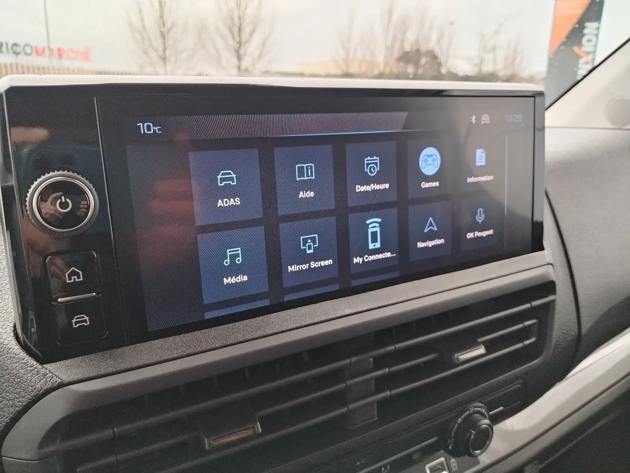 Écran tactile central du tableau de bord du Peugeot Expert gris Artense, affichant les options de connectivité et d'aide à la conduite.