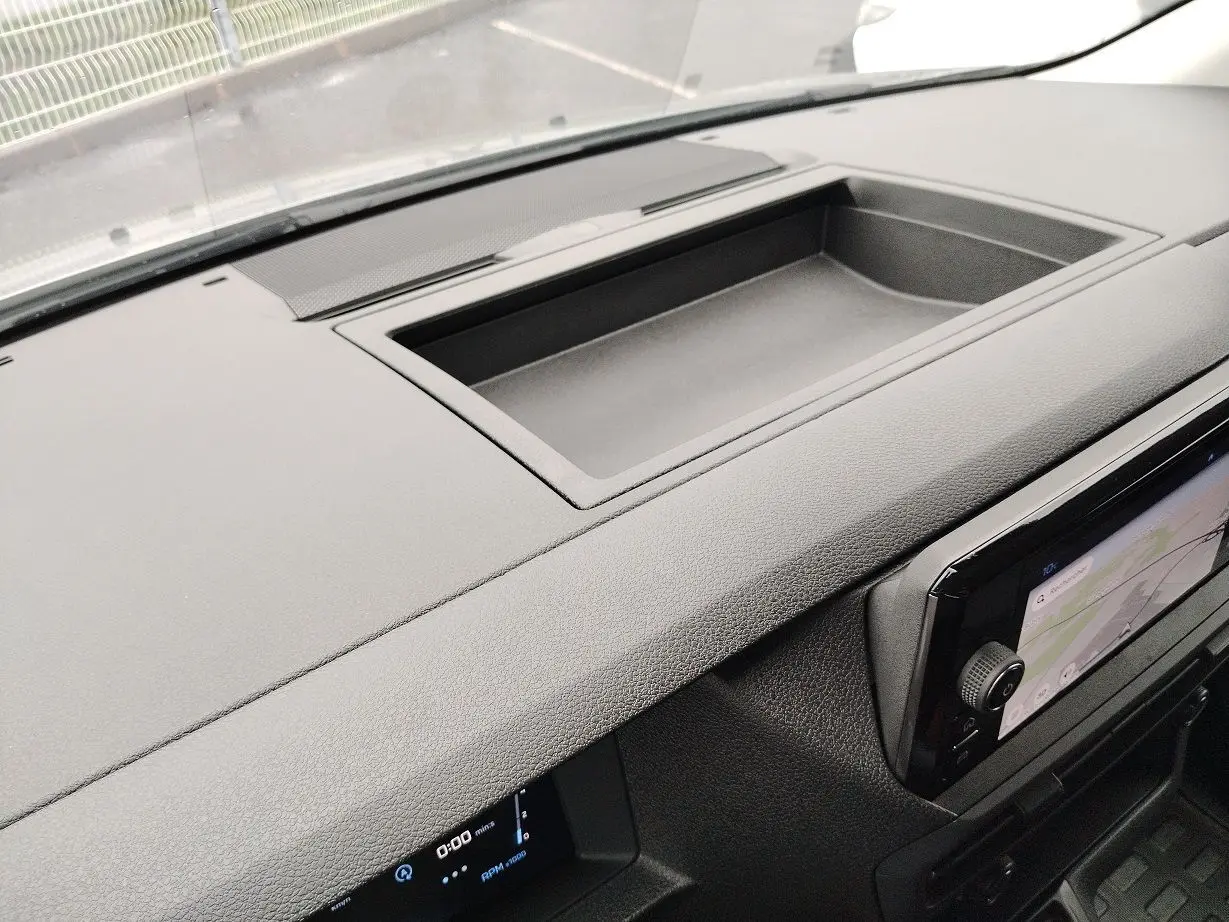 Vue rapprochée du tableau de bord noir du Peugeot Expert Cabine Approfondie 2025 avec écran tactile et rangement intégré.