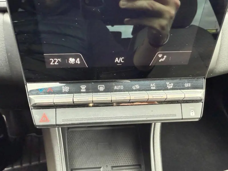 Vue rapprochée de la console centrale du Renault Captur 2025, affichant les commandes de climatisation et l'écran tactile.