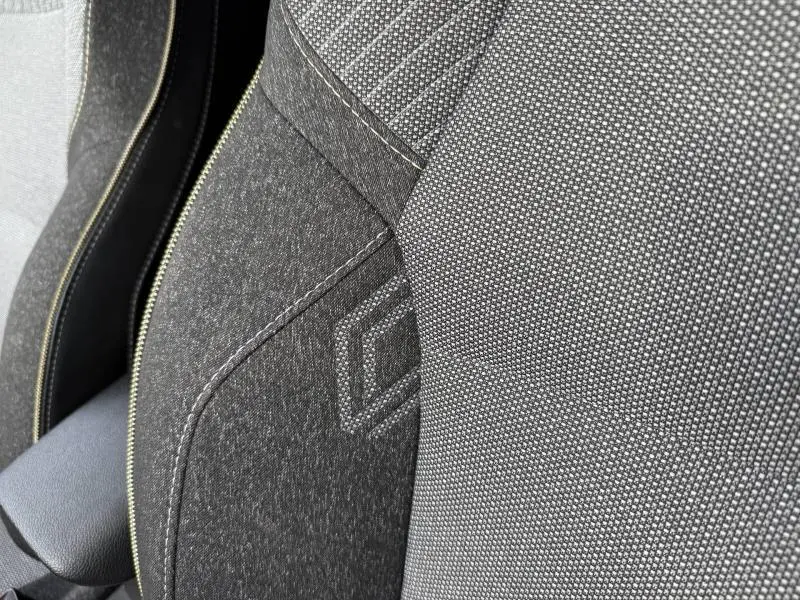 Gros plan sur le tissu gris et noir étoilé de la sellerie avant du Renault Captur 1.0 Eco-G 100ch Techno 2025.