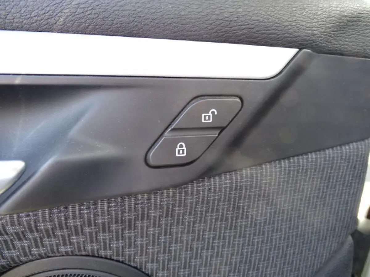 Détail des boutons de verrouillage sur la portière intérieure côté conducteur du BMW X1 blanc 2017.
