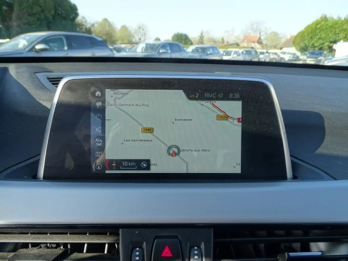 Vue intérieure centrée sur l'écran de navigation du tableau de bord d'une BMW X1 Business Design 2017.