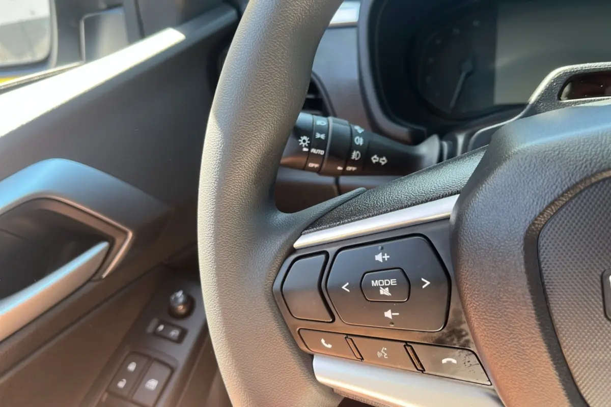 Gros plan sur le volant multifonctions noir de l'Isuzu D-MAX 2026 avec commandes audio et téléphone intégrées.