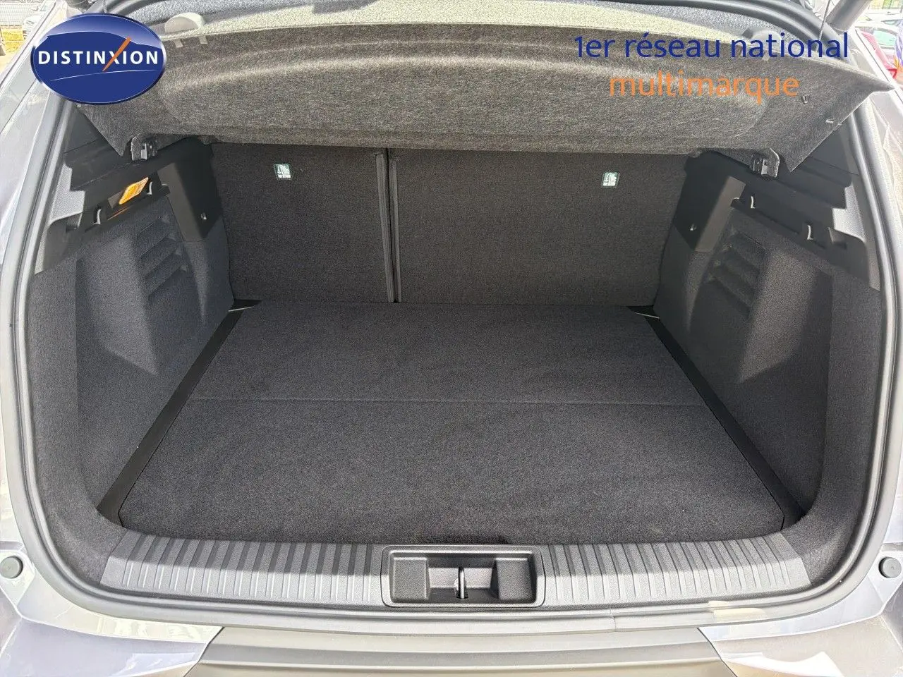 Coffre ouvert vu de l'arrière d'une Renault Symbioz gris cassiopée métal, espace de chargement propre et spacieux.