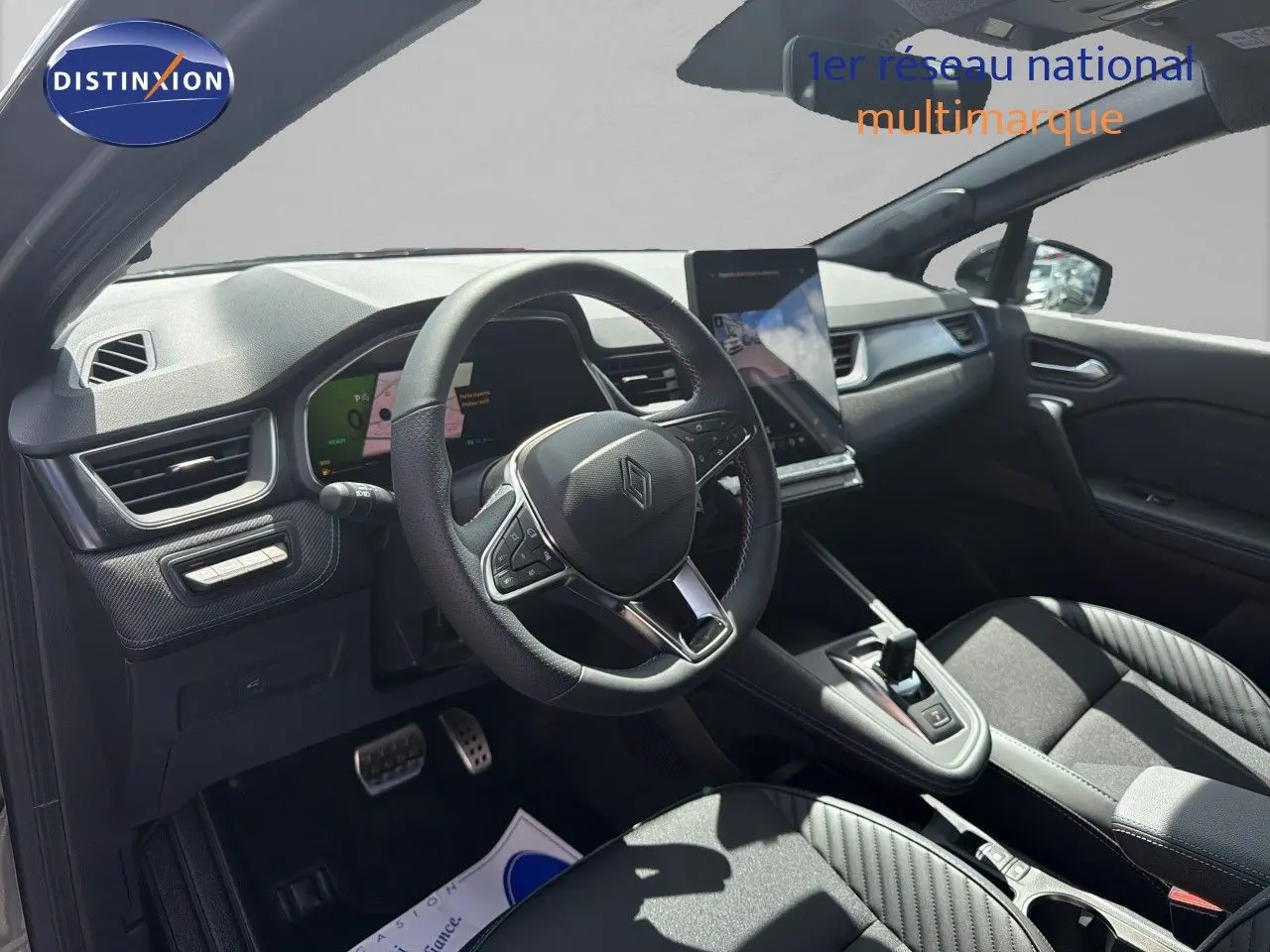 Vue intérieure côté conducteur de la Renault Symbioz gris cassiopée, volant cuir et écran tactile vertical lumineux.