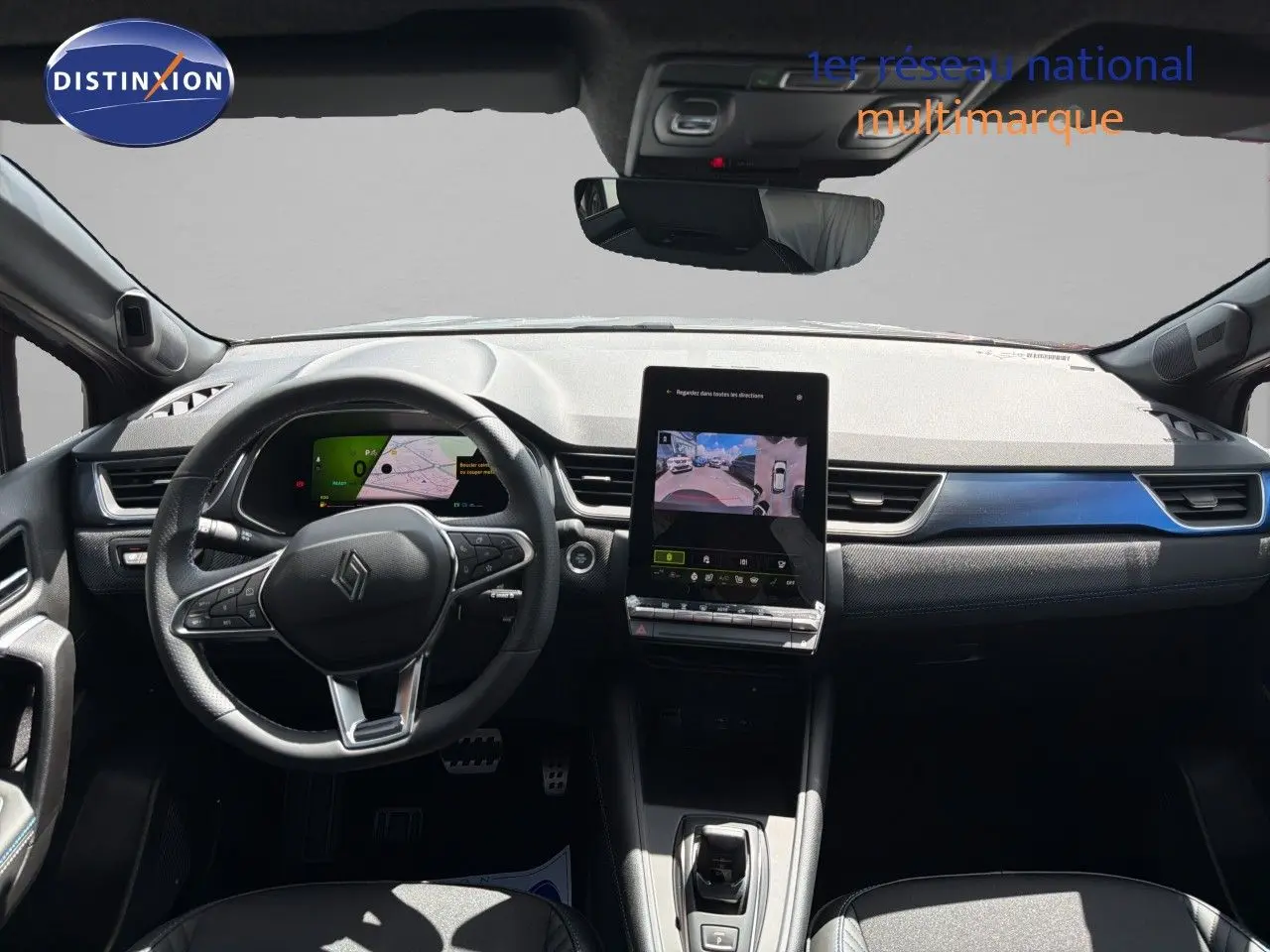 Vue intérieure avant du tableau de bord de la Renault Symbioz gris cassiopée, avec écran tactile central et volant multifonction.