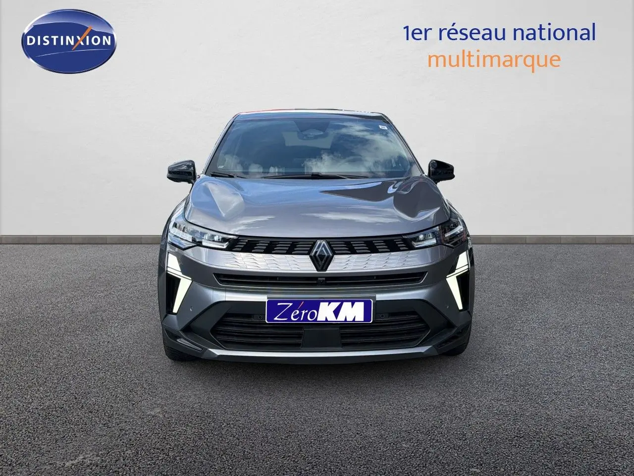 Vue frontale du Renault Symbioz gris cassiopée métallisé avec feux LED distinctifs allumés sur fond neutre.