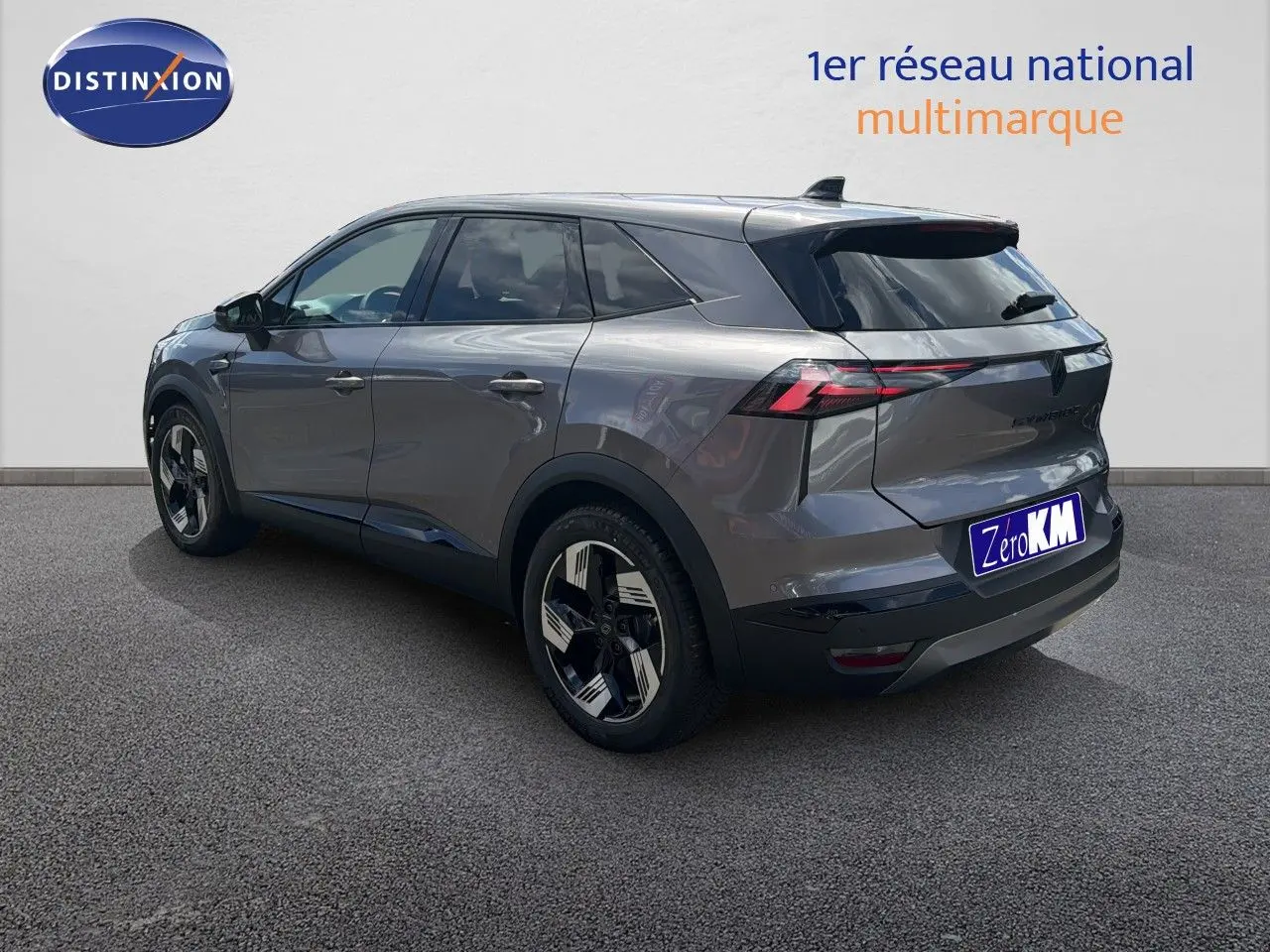 Renault Symbioz gris cassiopée métal vu en 3/4 arrière droit, avec jantes bicolores et feux arrière LED distinctifs.