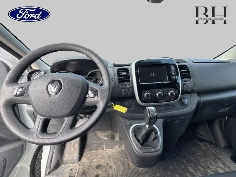 Tableau de bord et console centrale du Renault Trafic Fourgon blanc, avec levier de vitesse et écran tactile visible.