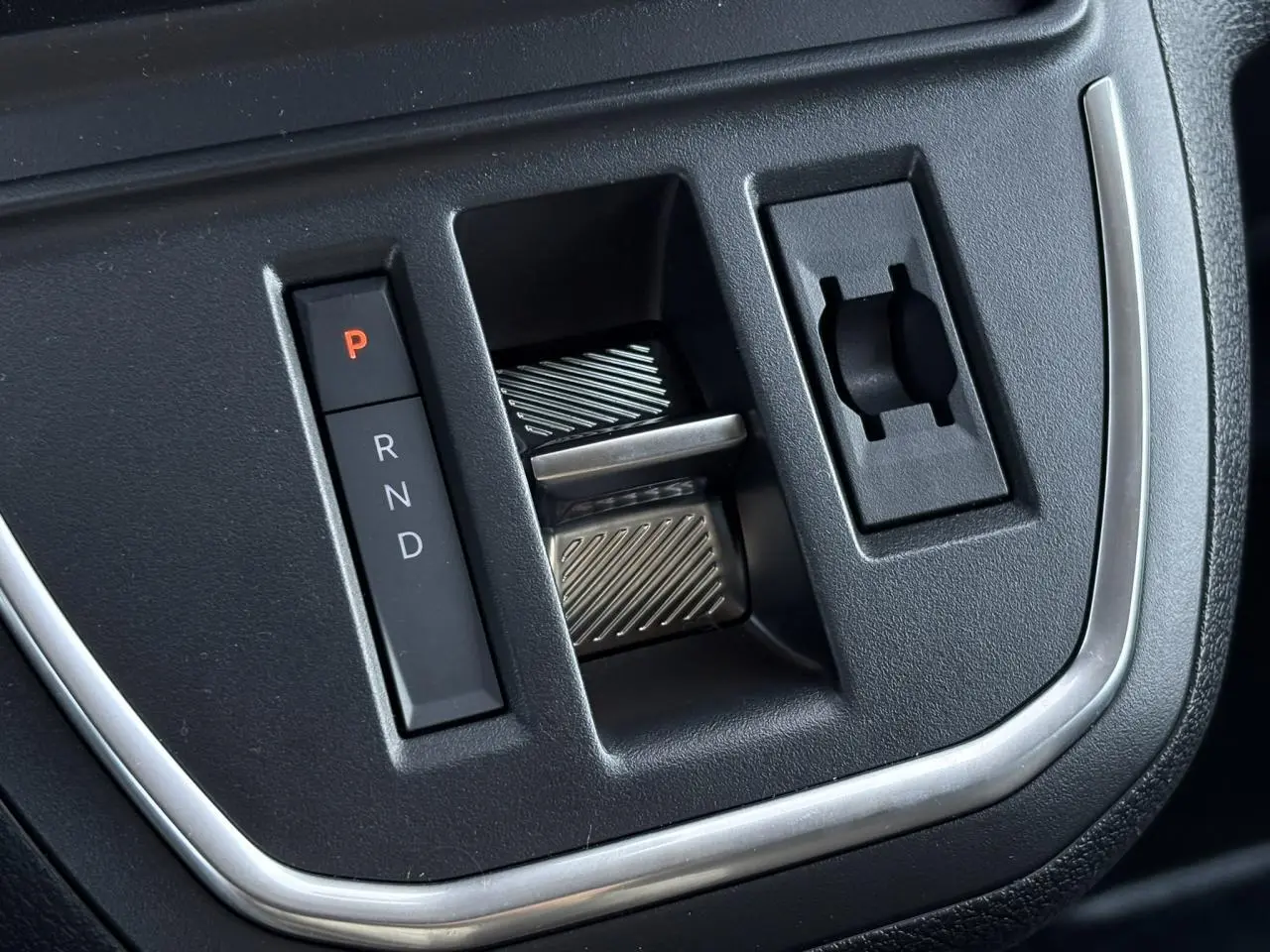 Gros plan sur la commande de boîte automatique noire avec sélecteur de vitesses P, R, N, D dans un Citroën Jumpy gris Titane.