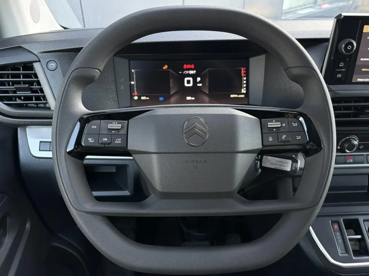 Vue rapprochée du volant noir de la Citroën Jumpy 2025 avec commandes intégrées et tableau de bord numérique.