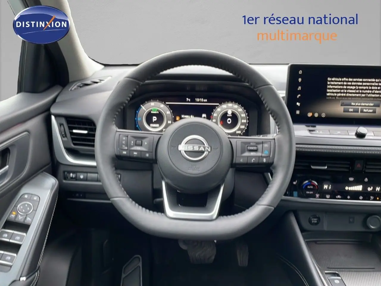 Vue intérieure centrée sur le volant du Nissan Qashqai blanc nacré, tableau de bord digital et écran tactile visible.