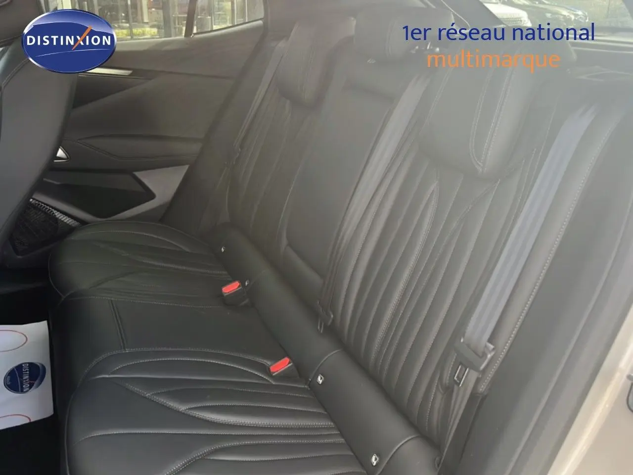 Vue intérieure côté droit des sièges arrière en cuir noir du DS4 2024 Cristal Pearl Nacré, avec ceintures de sécurité visibles.