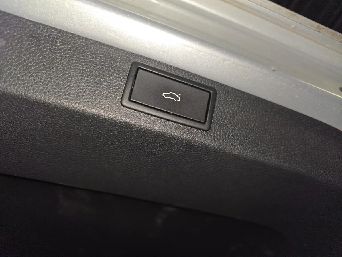 Bouton d'ouverture électrique du hayon dans le coffre du Skoda Karoq gris 2023.