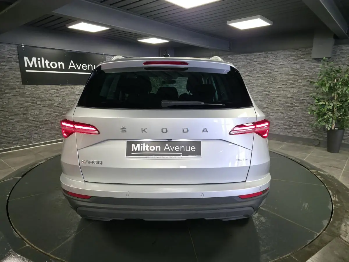 Vue arrière d'un Skoda Karoq gris 2023 avec feux LED allumés dans un showroom intérieur.