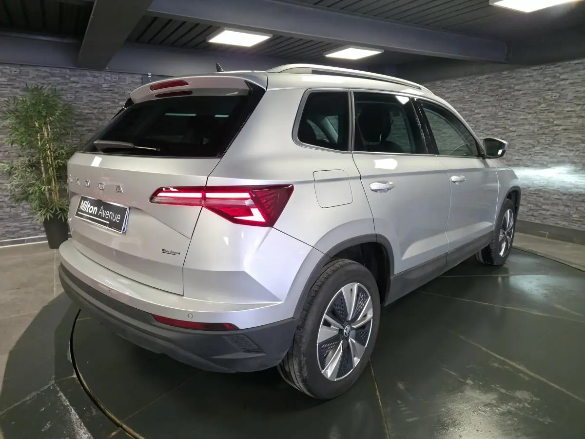 Vue 3/4 arrière droit du Skoda Karoq gris 2023 avec feux arrière LED et jantes alliage 17 pouces.