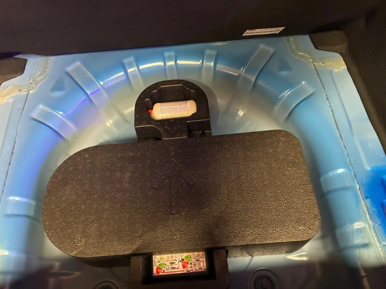 Détail du coffre montrant la roue de secours et le compartiment bleu clair sous le plancher d’une Ford Focus 2024.