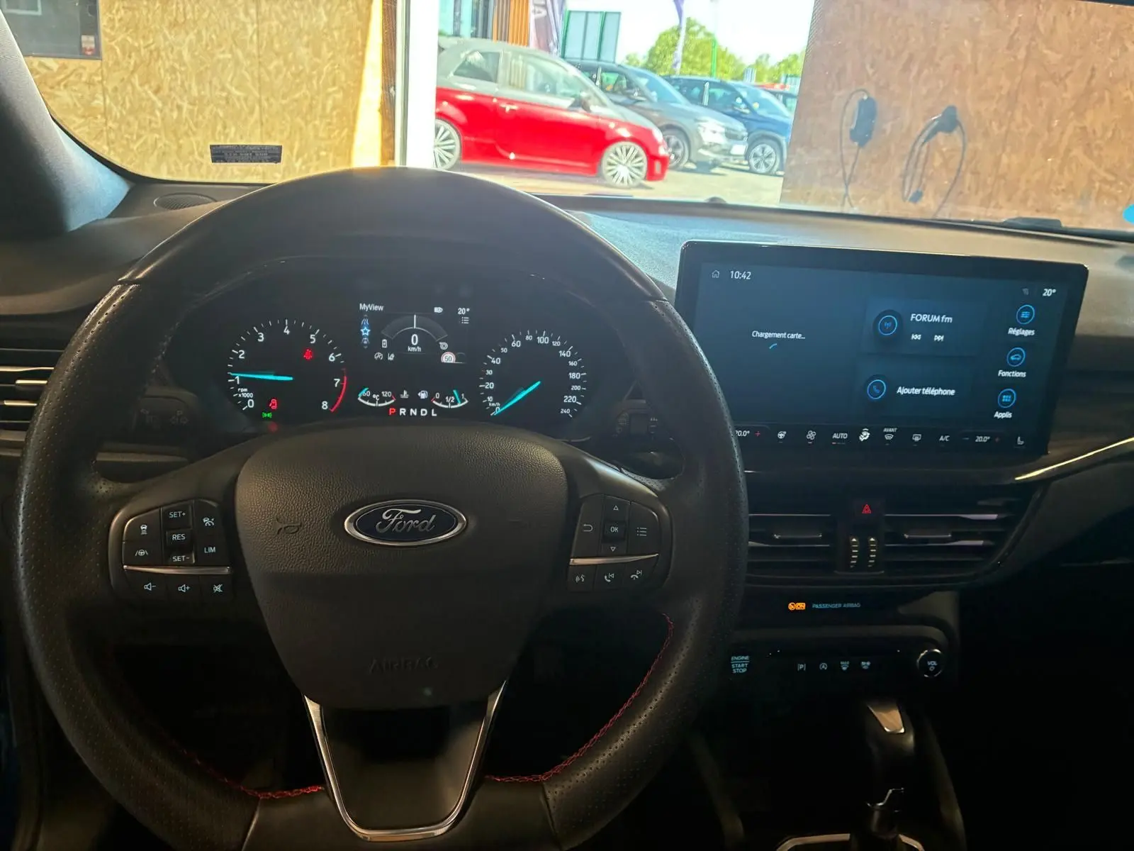Vue intérieure centrée sur le volant Ford et le tableau de bord numérique d'une Ford Focus bleu 2024.
