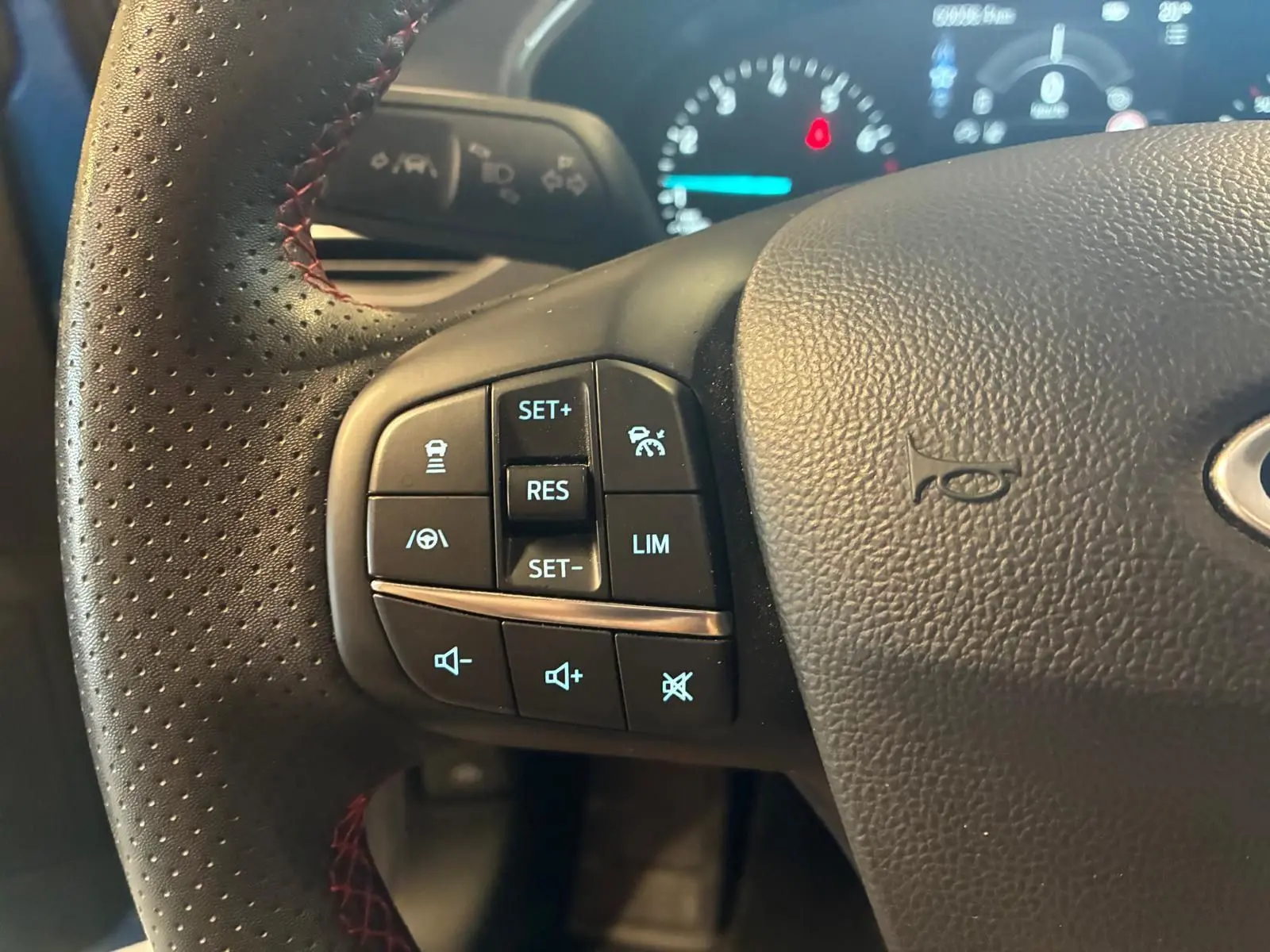 Gros plan sur le volant perforé noir avec commandes de régulateur et limiteur de vitesse de la Ford Focus 2024.