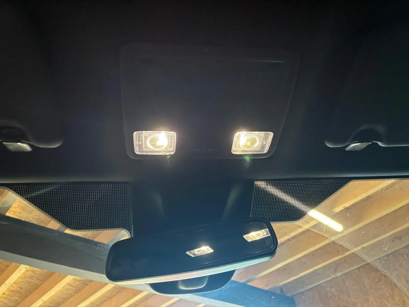 Vue intérieure centrée sur le rétroviseur et les plafonniers allumés d'une Ford Focus 2024.