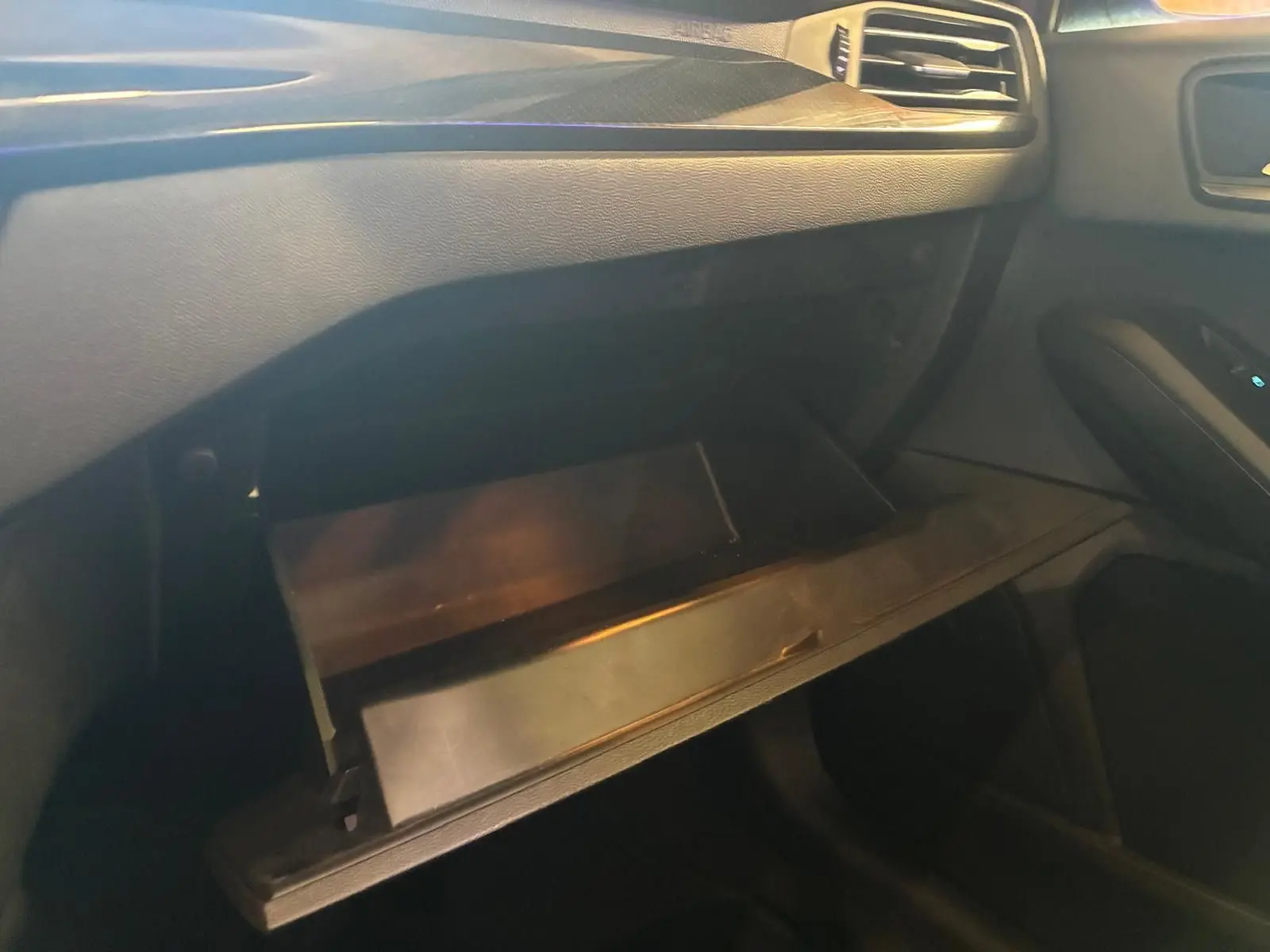 Vue intérieure côté passager de la boîte à gants ouverte sur la Ford Focus 2024 avec tableau de bord noir.