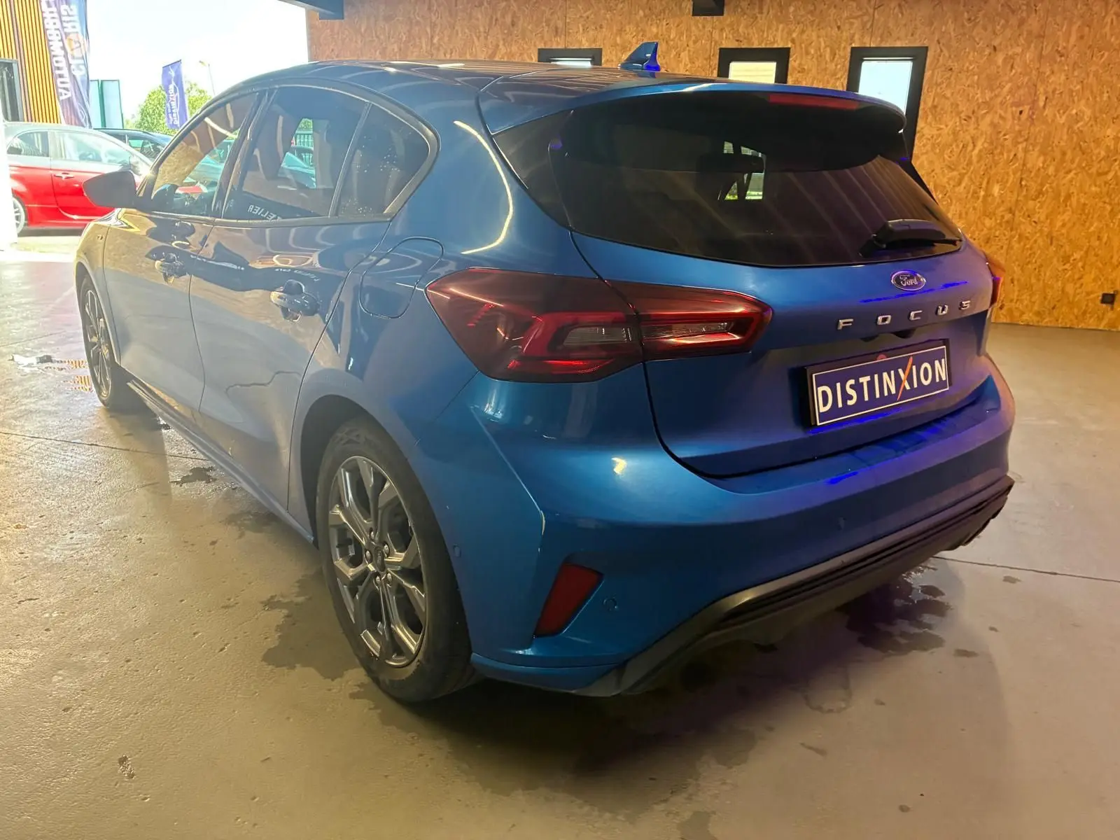 Vue 3/4 arrière droite d'une Ford Focus bleu 2024 ST Line avec feux LED et toit avec antenne requin.
