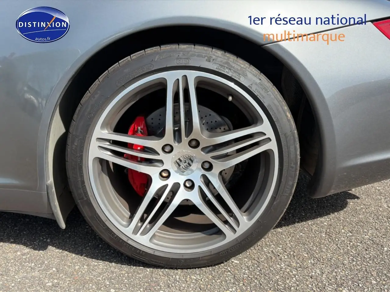 Gros plan sur la roue arrière droite grise d'une Porsche 911 (997) Carrera S avec étrier de frein rouge visible.
