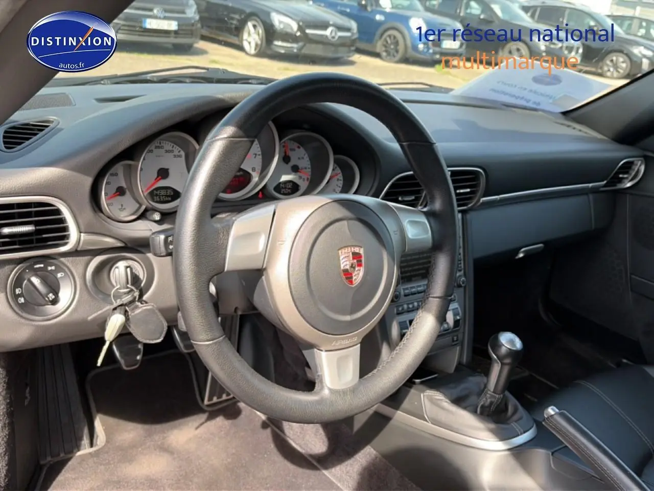 Vue intérieure de la Porsche 911 (997) Carrera S 2008, volant cuir, tableau de bord et levier de vitesse manuel visibles.