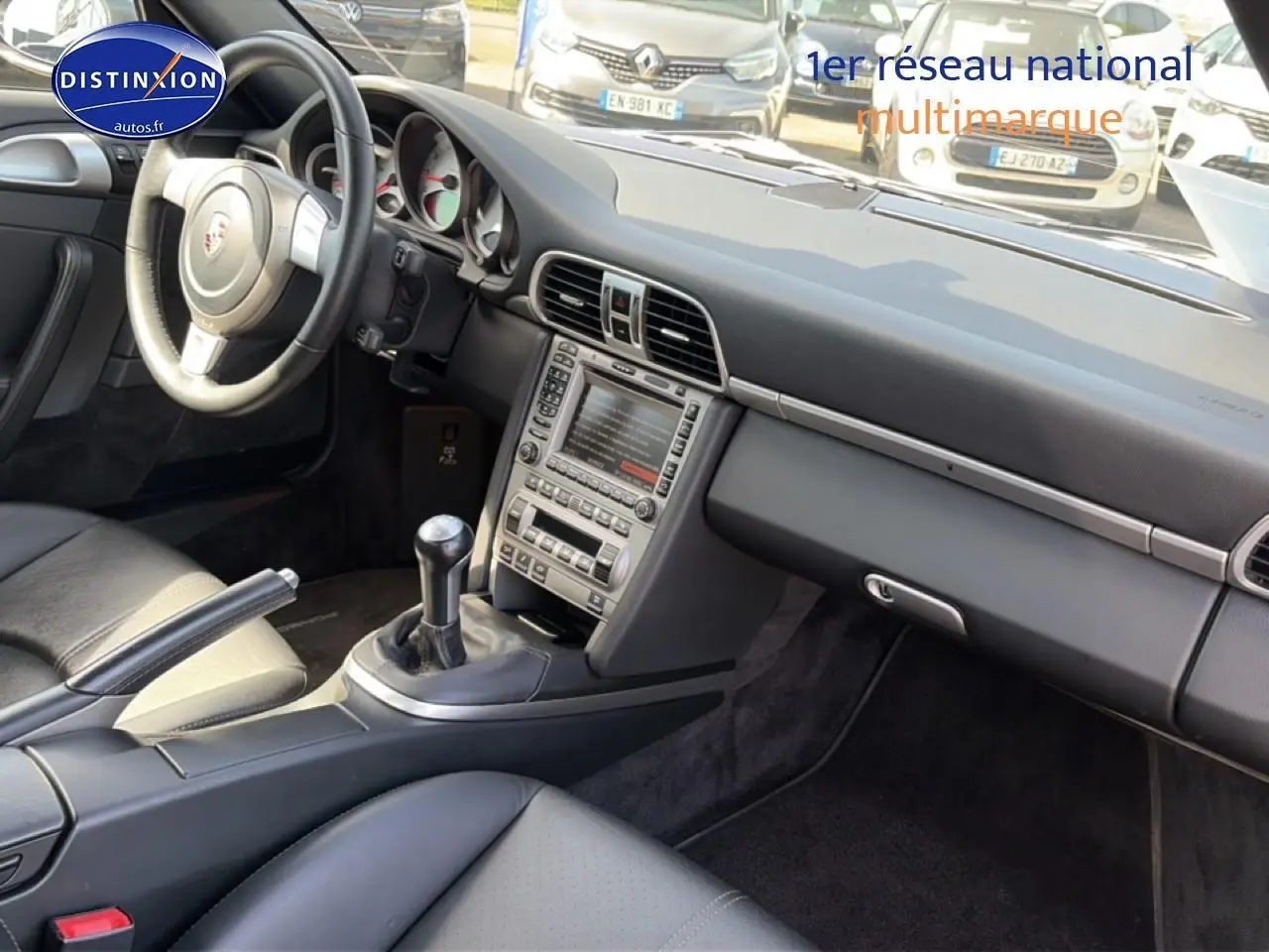 Intérieur de Porsche 911 (997) Carrera S 2008 vu côté passager, montrant tableau de bord et boîte manuelle cuir noir.
