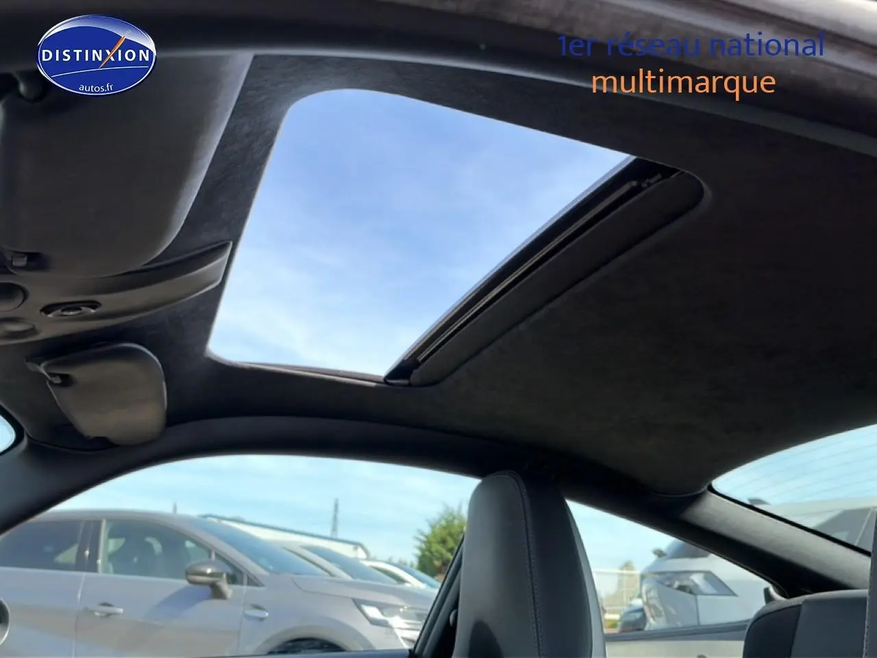 Vue intérieure du toit ouvrant électrique de la Porsche 911 (997) Carrera S gris, avec ciel bleu visible à travers.