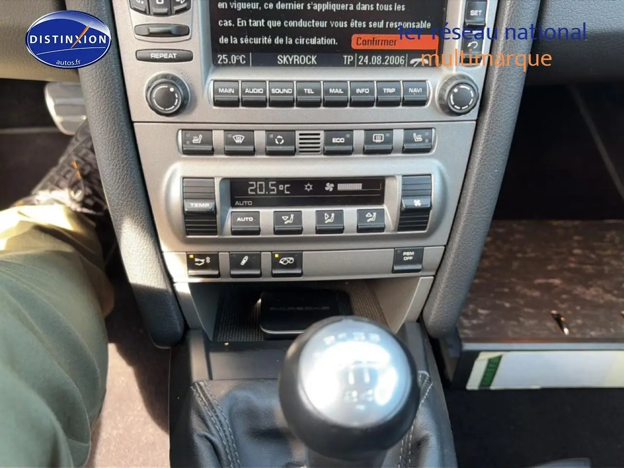 Vue rapprochée de la console centrale et levier de vitesses manuel d'une Porsche 911 (997) Carrera S gris, intérieur cuir.