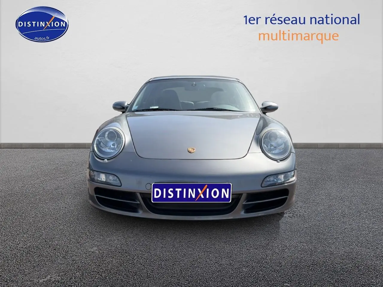 Vue frontale d'une Porsche 911 (997) Carrera S gris métallisé, avec phares ronds caractéristiques et calandre basse.