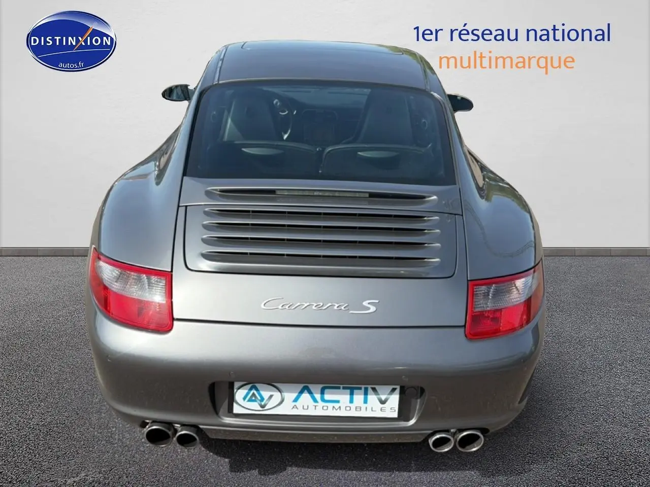 Vue arrière d'une Porsche 911 (997) Carrera S gris métallisé avec double sortie d'échappement et toit ouvrant électrique visible.