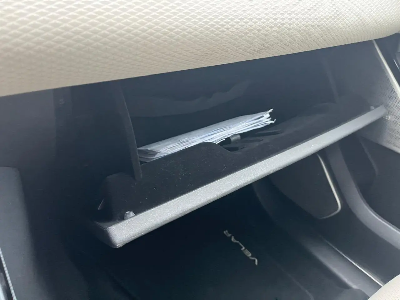 Gros plan sur la boîte à gants ouverte du Range Rover Velar 2017, montrant des documents à l'intérieur.