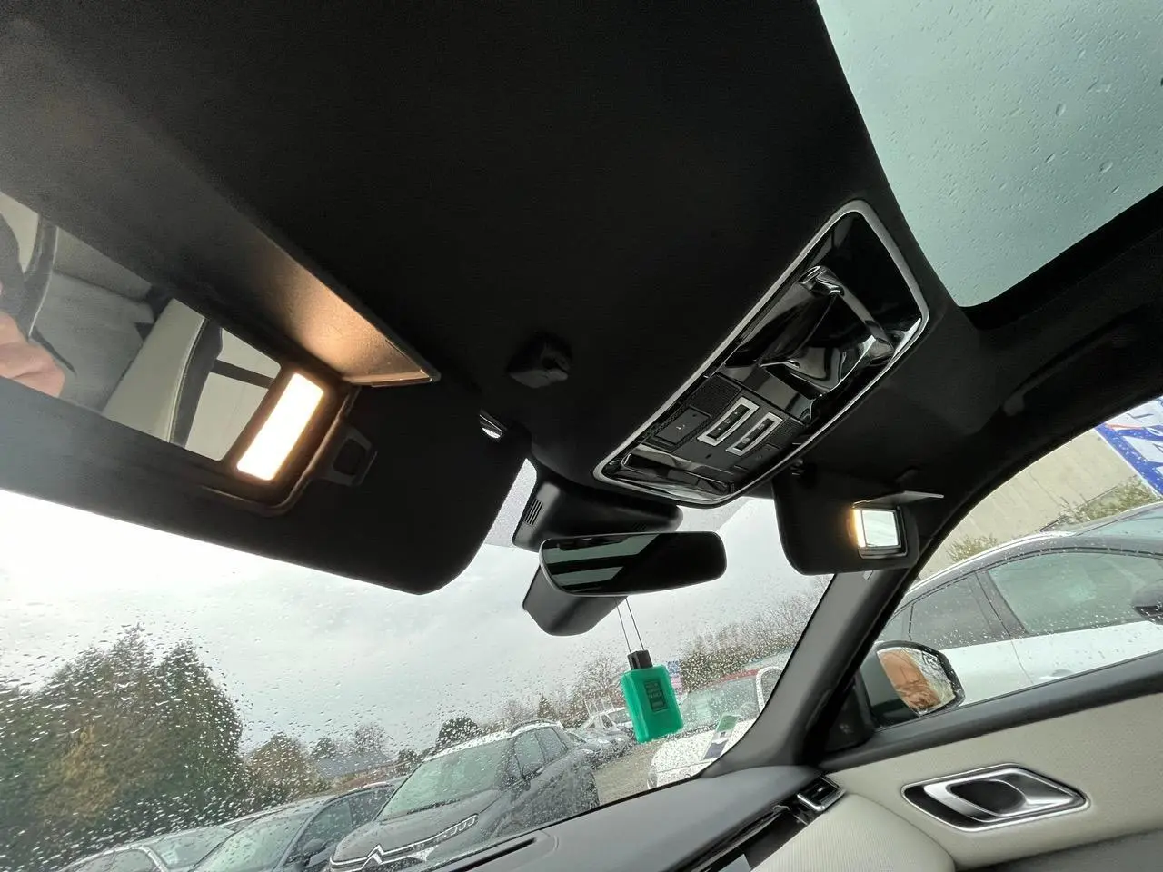 Vue intérieure du Range Rover Velar 2017 côté droit, montrant le toit ouvrant panoramique et les miroirs de courtoisie éclairés.