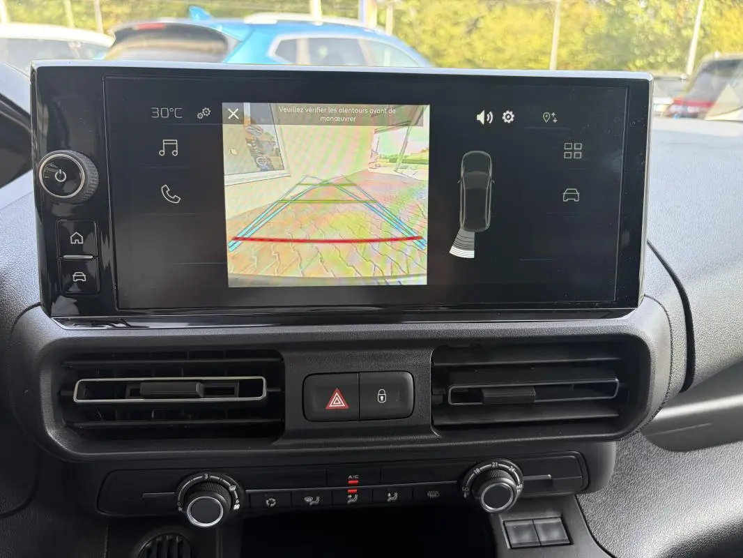 Écran tactile central du Peugeot Partner 2026 montrant la caméra de recul, avec les aérateurs et commandes de climatisation visibles.