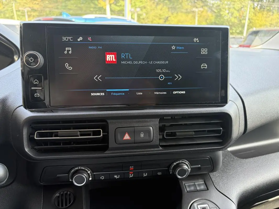 Écran tactile central du Peugeot Partner 2026 affichant la radio RTL, avec commandes de climatisation et ventilation visibles.